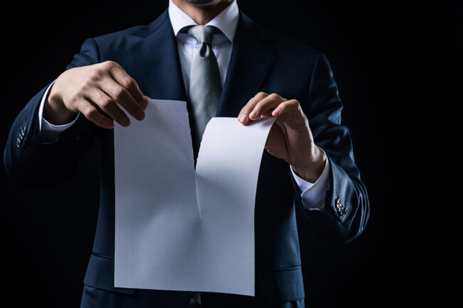 白紙の紙を破るビジネスマン