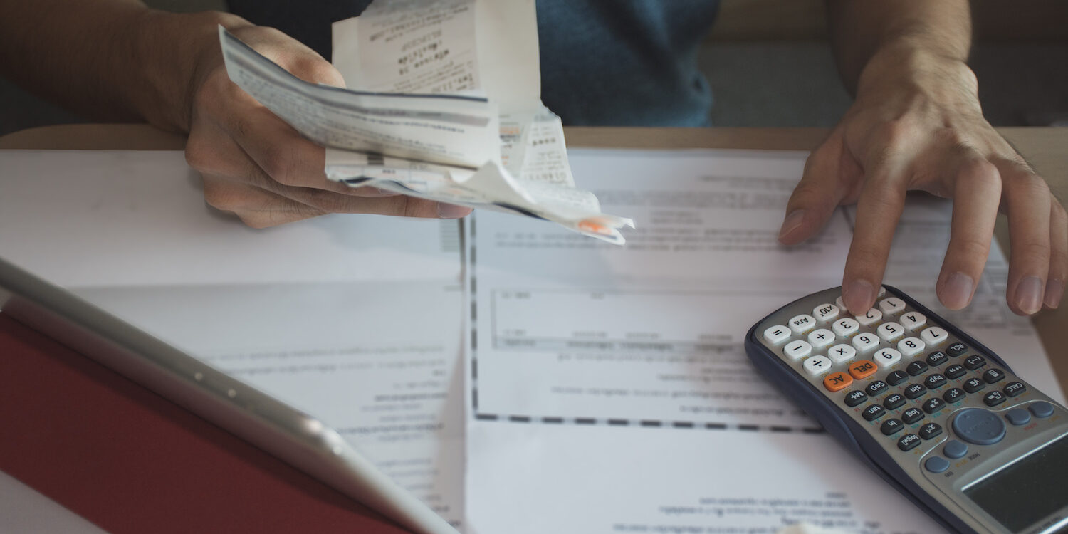 man using calculator for calculate expenses accounts