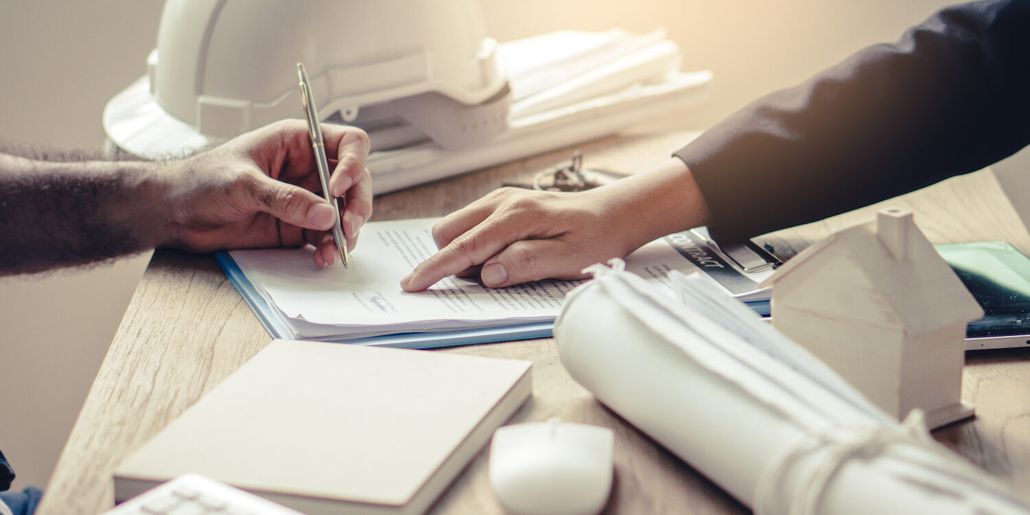 Business partners contract agreement success. Top view of close up hand of bank broker showing to client where to sign signature in contract for housing loan. Document in picture is fake.