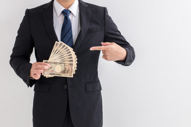 スーツを着た男性が10万円持っている 給付金 援助 コロナ man money business